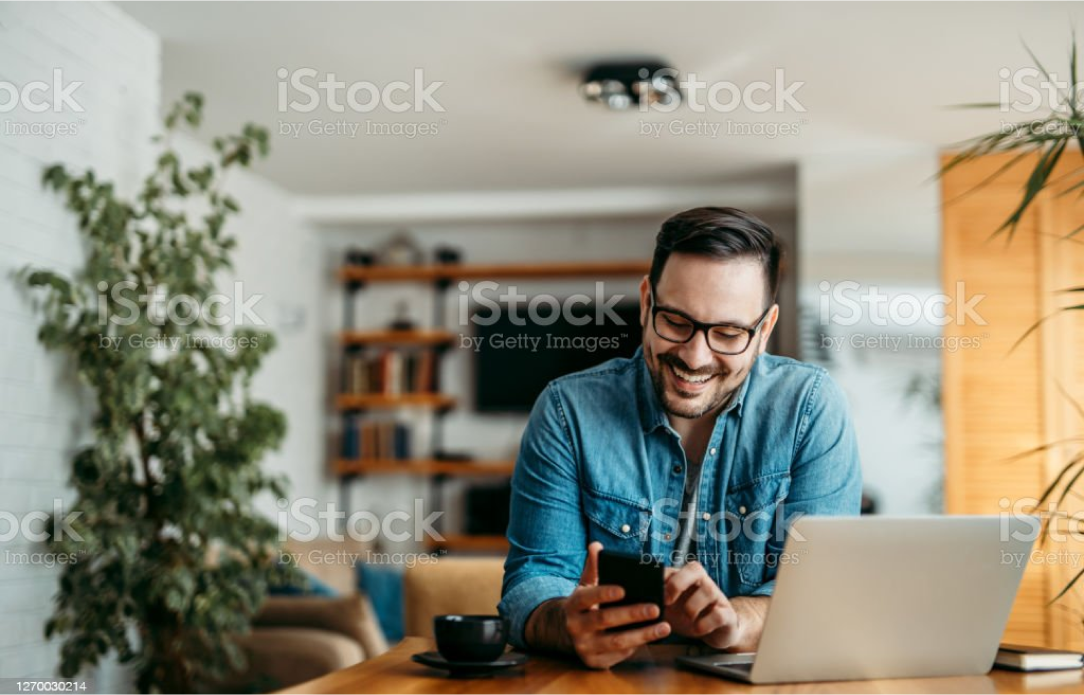 Man working at desk looking on phone