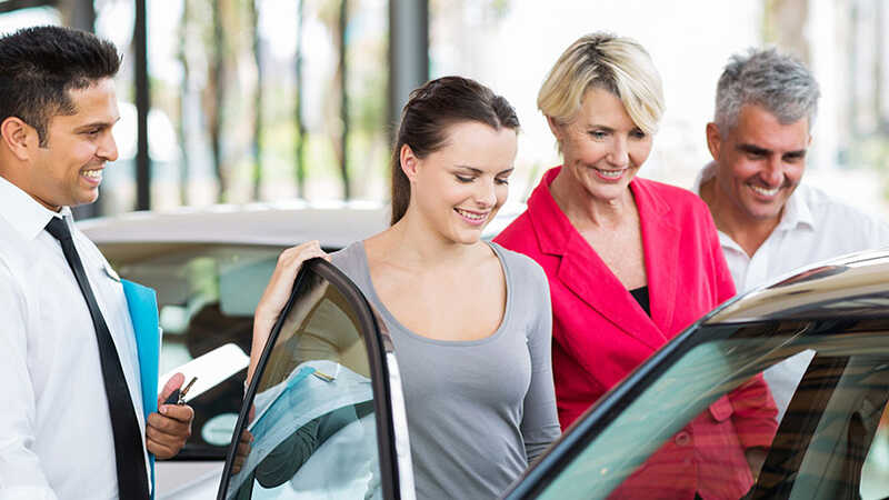 Woman inspecting a car for sale