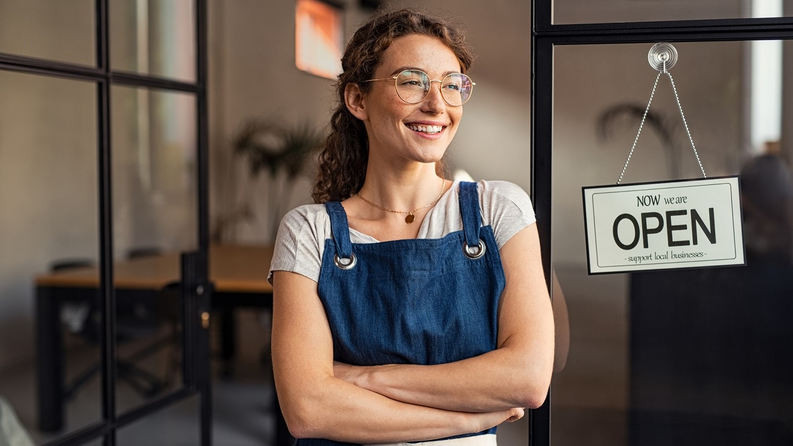 Small business owner smiling at their store